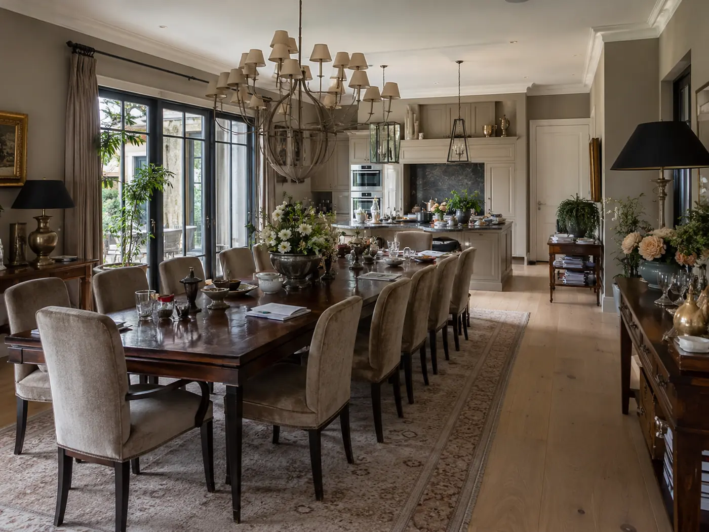 Keuken en eetruimte vóór de werkzaamheden, met veel decoratie, spullen op tafel en aanrecht en een volle uitstraling.