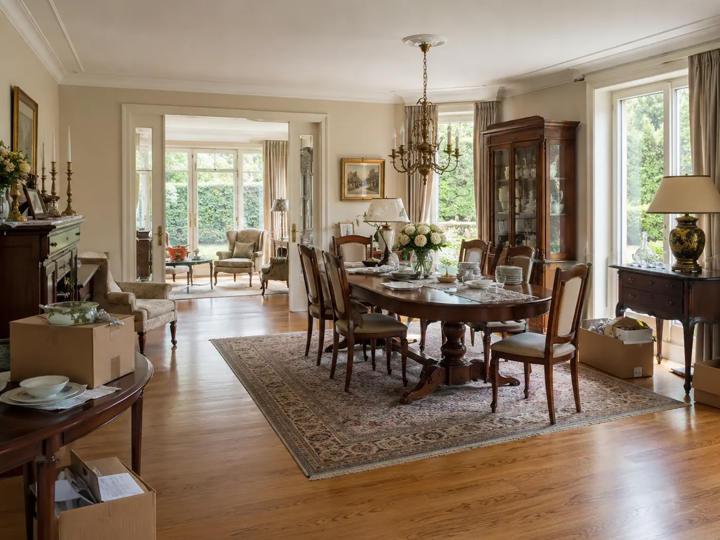Eetkamer vóór de ontruiming, met grote eettafel, stoelen, servieskast en overige inboedel.