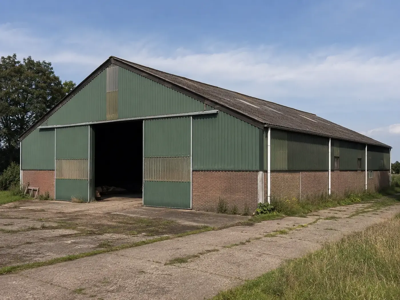 Grote groene loods op het platteland die leeggehaald wordt