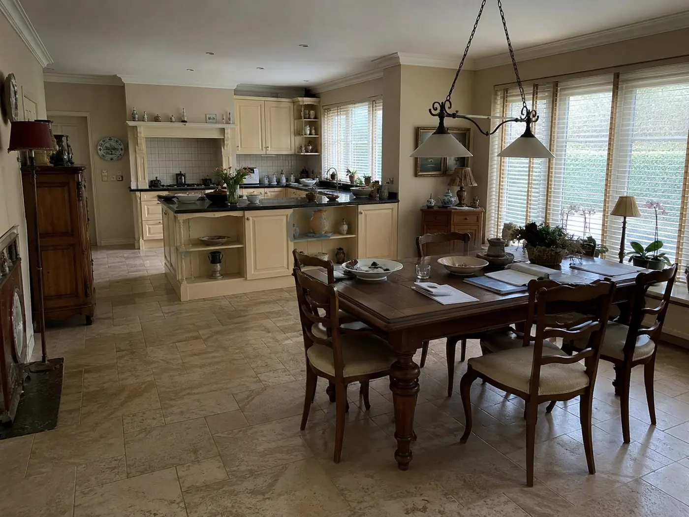 Keuken en eetruimte vóór de werkzaamheden, met oudere inrichting, luxaflex, persoonlijke spullen en een minder lichte uitstraling.