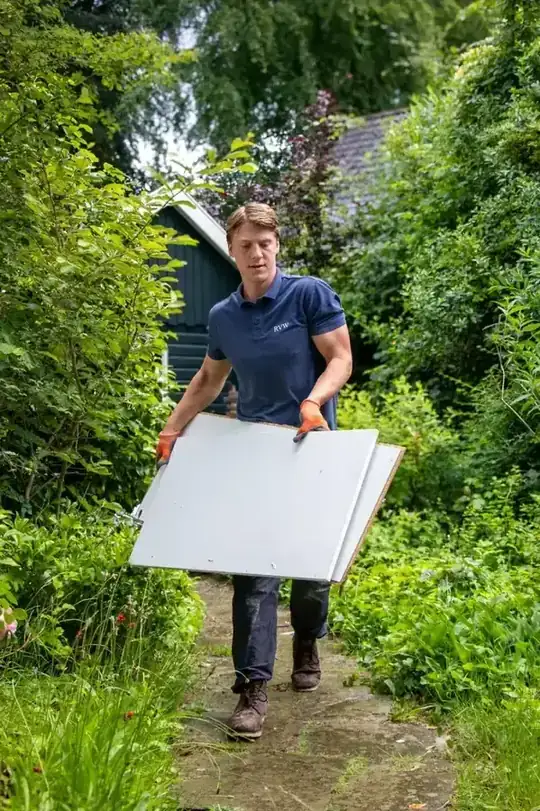 Medewerkers halen meubels uit een woning tijdens de ontruiming