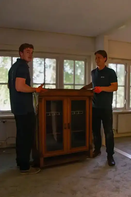 Team van Ruimte voor Wonen ontruimt een woning en draagt inboedel naar buiten